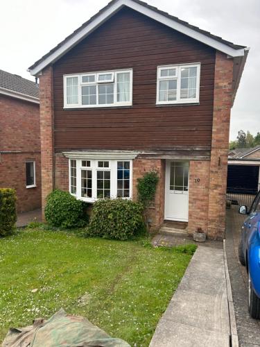 a brick house with white windows and a driveway at Number 10 in Chepstow