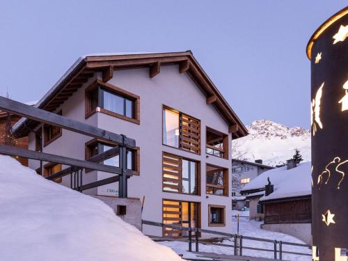 una casa en las montañas con nieve en el suelo en Apartment Turrabuel 7-Bett Deluxe by Interhome, en Parpan