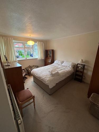 a bedroom with a bed and a chair and a window at Number 10 in Chepstow