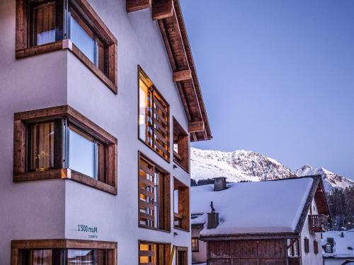 un bâtiment avec des fenêtres et une montagne enneigée dans l'établissement Apartment Turrabuel 2-Bett Superior by Interhome, à Parpan