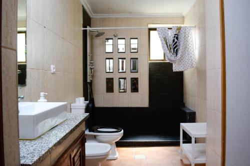 a bathroom with a sink and a toilet and a tub at Live Oporto Rooms in Porto