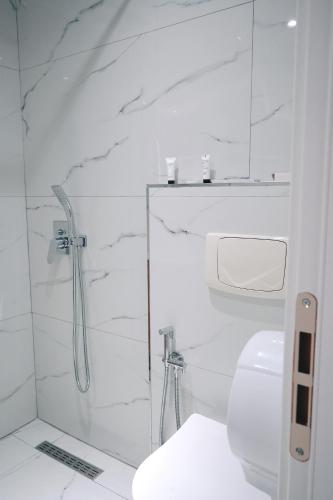 a white bathroom with a shower and a toilet at Ufo Rooms City Center in Tirana