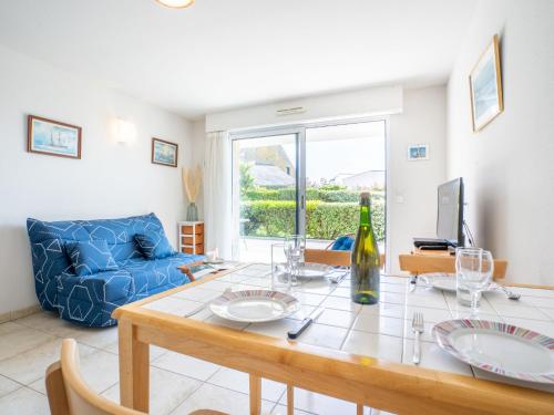 un salon avec une table et un canapé bleu dans l'établissement Apartment Résidence Villa Cassandre by Interhome, à Quiberon