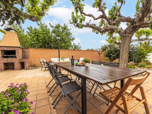 un patio con mesa de madera y sillas en Holiday Home Torre del Sol by Interhome, en Tarragona