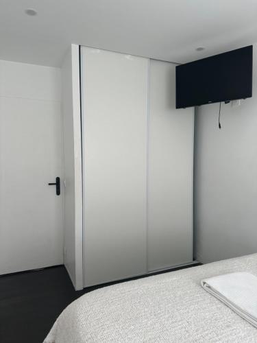 a bedroom with a sliding white door and a bed at Location de chambre privée dans résidence privée,parking gratuit , 1 minute du tramway, à 9 minute du centre ville, accessible à plusieurs transports in Nice
