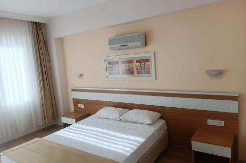ein Schlafzimmer mit einem Bett und einer Klimaanlage an der Wand in der Unterkunft Alexius Beach Hotel in Beldibi