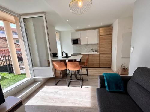 un salon avec un canapé et une table avec des chaises dans l'établissement Emma - 4/6 pers NEUF- Hyper centre Clim Terrasse, à Saint-Raphaël