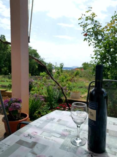 a bottle of wine sitting on a table with a glass at Apartment Ani in Slano