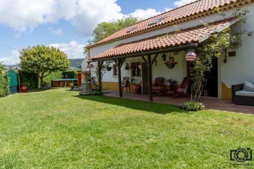 a house with a patio and a yard at Refúgio Verde in Painho