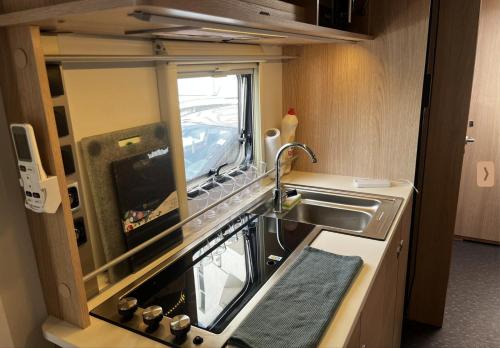 a small kitchen with a sink and a sink at Hilazon Caravan in Ashdod