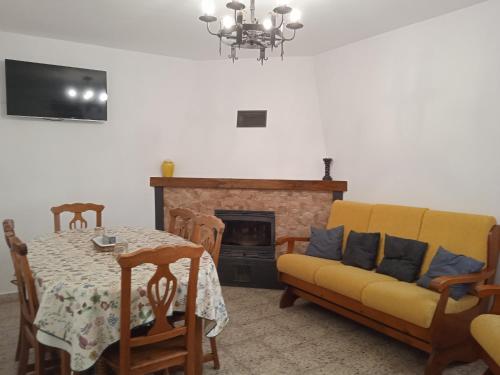 a living room with a table and a couch and a fireplace at Casa Rural Cariño in Armañanzas
