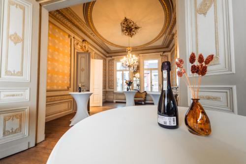 een kamer met een tafel met twee flessen wijn bij Luxeverblijf B&B het Wevershuis in Herentals