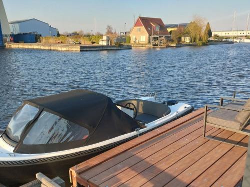 a boat parked at a dock on a body of water at Holiday Home Harboursuite Woudsend incl- motorboot by Interhome in Woudsend