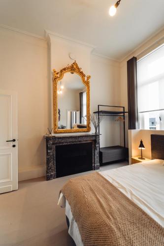 ヘーレンタルスにあるLuxeverblijf B&B het Wevershuisの暖炉と鏡付きのベッドルーム