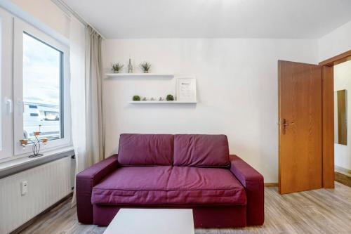 a purple couch in a living room with a window at Fewo Nele in Gries