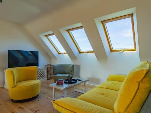 een woonkamer met een gele bank en een tv bij Holiday Home Ty Mat by Interhome in Guimaëc