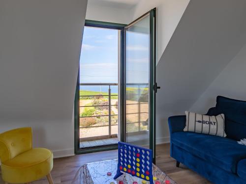 un salon avec un canapé bleu et une chaise dans l'établissement Holiday Home Ty Mat by Interhome, à Guimaëc