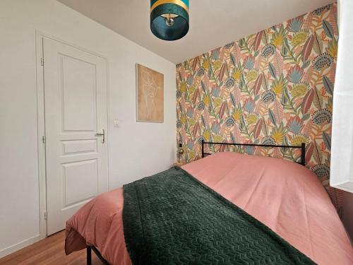 - une chambre avec un lit et un mur coloré dans l'établissement Appartement coeur de ville !, à Saint-Omer