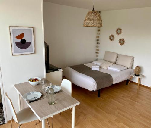 Habitación pequeña con cama y mesa en Superbe appartement confortable, proche centre ville, en Rennes