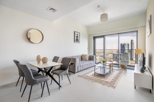 een woonkamer met een bank en een tafel en stoelen bij The Downtown Dubai Collection in Dubai