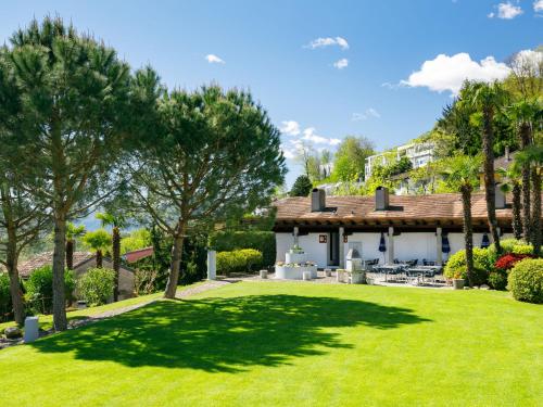 a house with a large lawn in front of it at Apartment Villaggio Sureggio A1 mit TicinoTicket by Interhome in Lugaggia