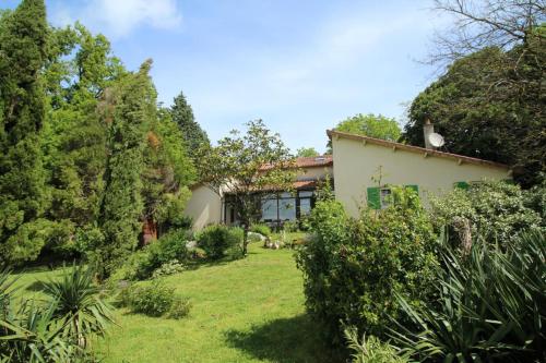 a house with a yard with bushes and trees at La maison de claire in Saint-Ouen-sur-Gartempe