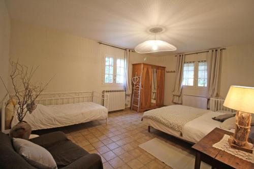 a living room with two beds and a couch at La maison de claire in Saint-Ouen-sur-Gartempe