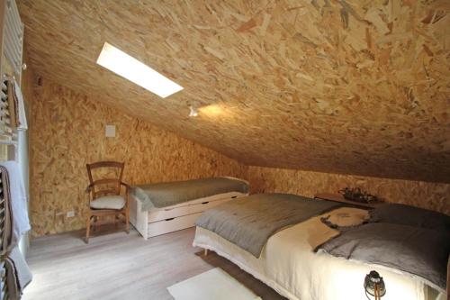 a bedroom with a bed and a chair at La maison de claire in Saint-Ouen-sur-Gartempe