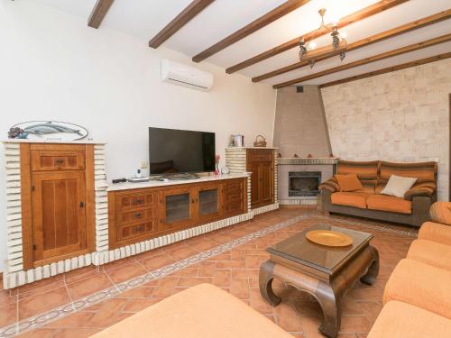 een woonkamer met een bank en een tv bij Holiday Home Vereda Cádiz Conil by Interhome in Chiclana de la Frontera