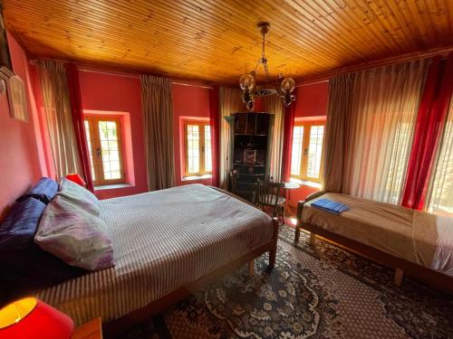 a bedroom with red walls and a bed and windows at Rooms for Rent in Shkodër