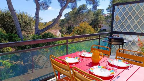 un balcon avec une table rouge et des chaises dans l'établissement VILLA REIALA Saint-Raphaël, à Saint-Raphaël