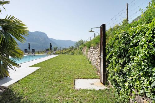 a fence next to a swimming pool next to a wall at Bacchushof Apartment Merlot in Termeno