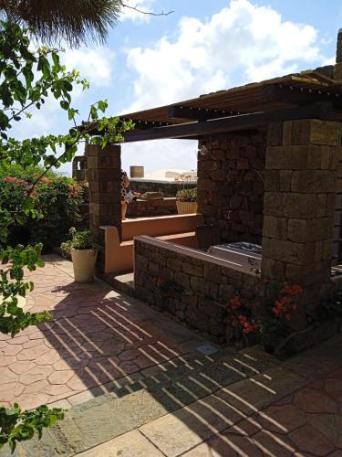 a patio with a bench and a brick wall at Dammuso Libeccio in Pantelleria
