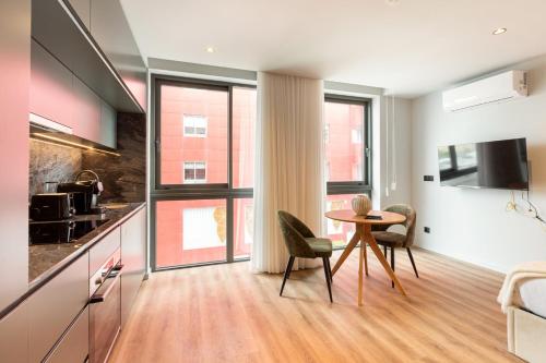 a kitchen and living room with a table and chairs at GuestReady - Stylish studio in Gaia in Vila Nova de Gaia