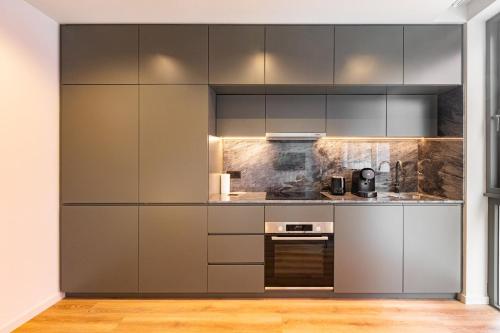 a kitchen with gray cabinets and a stove at GuestReady - Stylish studio in Gaia in Vila Nova de Gaia