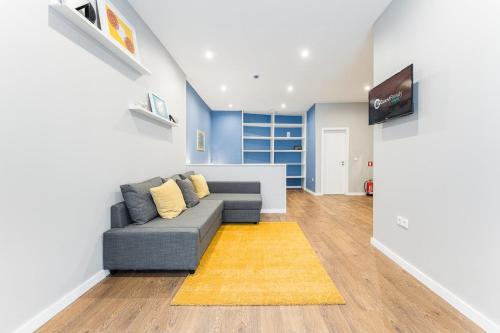 ein Wohnzimmer mit einem Sofa und einem TV in der Unterkunft GuestReady - The New Lazuli Flat in Porto