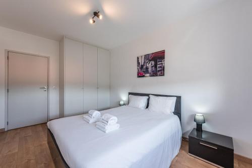 ein Schlafzimmer mit einem großen weißen Bett mit Handtüchern darauf in der Unterkunft GuestReady - Never Say Never in Porto