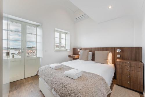 - une chambre blanche avec un grand lit et une fenêtre dans l'établissement GuestReady - Riverview Douro Terrace, à Vila Nova de Gaia