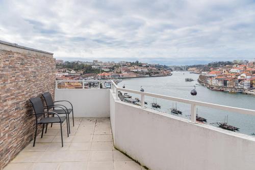 d'un balcon avec des chaises et une vue sur la rivière. dans l'établissement GuestReady - Riverview Douro Terrace, à Vila Nova de Gaia