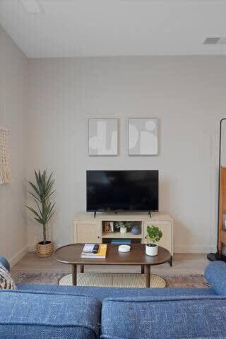 a living room with a blue couch and a table at CozySuites Spacious SDO, Lawrenceville in Pittsburgh