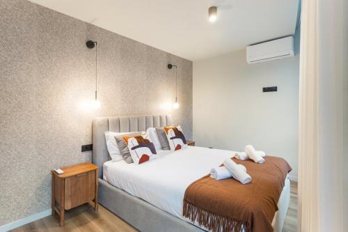 a bedroom with a large bed with towels on it at GuestReady - Khaki Roof in Vila Nova de Gaia