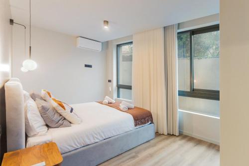 a bedroom with a bed and a large window at GuestReady - Khaki Roof in Santo Ovídio