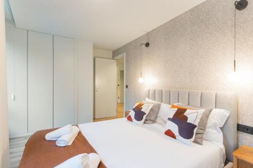 a bedroom with two beds with white sheets and pillows at GuestReady - Khaki Roof in Vila Nova de Gaia