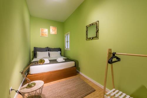ein Schlafzimmer mit einem Bett in einer grünen Wand in der Unterkunft GuestReady - Miragaia Green in Porto