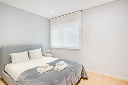 um quarto com uma cama com duas toalhas em GuestReady - Ideal Getaway minutes from Porto em Gondomar
