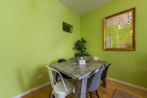 ein Esszimmer mit grünen Wänden sowie einem Tisch und Stühlen in der Unterkunft GuestReady - Miragaia Green in Porto