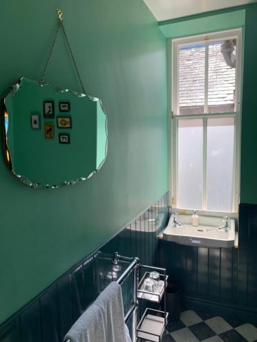 Leven House Bed and Breakfast في كريف: حمام مع حوض ومرآة
