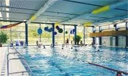 - une grande piscine avec des personnes à l'eau dans l'établissement Villa Am Rosenfelspark, à Lörrach