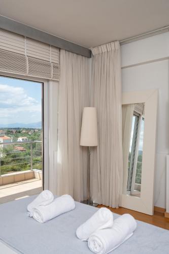 a bedroom with a bed with two pillows and a window at 3 Palm Villa in Chalkida