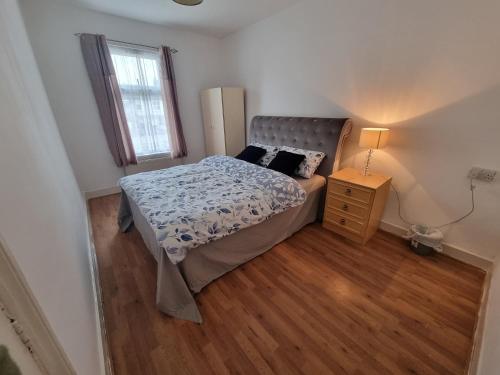 a small bedroom with a bed and a night stand at ilford town house in Ilford